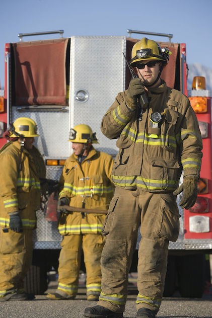 Fireman using walkie talkie by fire engine